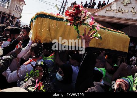 Majdal Slim, Liban. 20 août 2024. Les personnes en deuil jettent des fleurs sur le cercueil du combattant du Hezbollah Abbas Badii Milhim, né en 1990 avec l'indicatif d'appel "Jihad" qui a été tué par les forces israéliennes dans le sud du Liban lors de sa cérémonie funéraire. Crédit : SOPA images Limited/Alamy Live News Banque D'Images