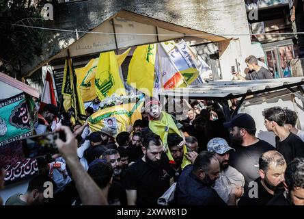 Majdal Slim, Liban. 20 août 2024. Les personnes en deuil portent le cercueil du combattant du Hezbollah Abbas Badii Milhim, né en 1990 avec l'indicatif d'appel "Jihad" qui a été tué par les forces israéliennes dans le sud du Liban lors de sa cérémonie funéraire. (Photo de Vasily Krestyaninov/SOPA images/SIPA USA) crédit : SIPA USA/Alamy Live News Banque D'Images