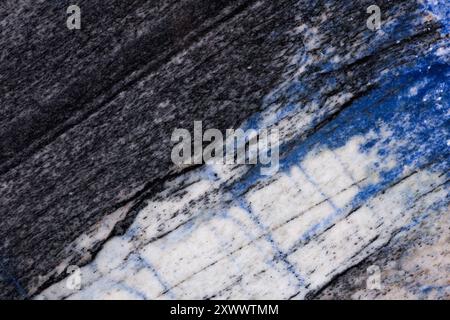 Gros plan d'une texture granitique de haute qualité avec des veines minérales noires, blanches et bleues. Banque D'Images