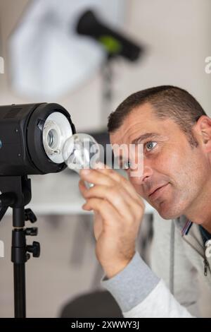 photographe devant la lampe de studio avec lampe de poche Banque D'Images