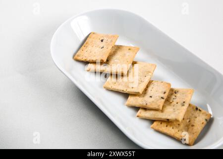 Biscuit Cracker carré avec arôme végétal et miettes de White plate Banque D'Images