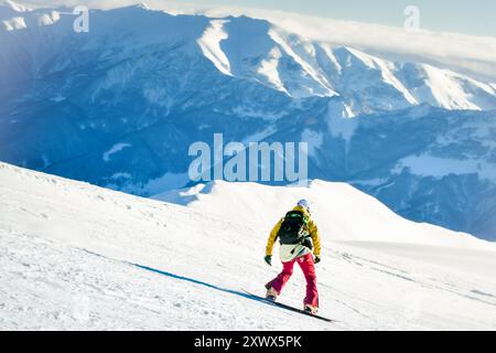 Vue de côté skieur masculin porter tenue colorée isolé sur piste ski descente rapide mouvement dans les Alpes. Vacances d'hiver actives, ski en descente par jour couvert. Banque D'Images