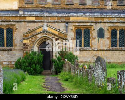 Chemin bordé de vieilles pierres tombales menant à l'église de St Michael dans le village de Church Stowe, Northamptonshire, Royaume-Uni Banque D'Images