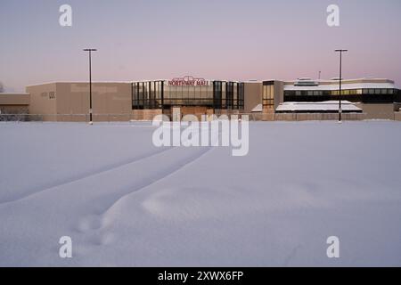 Un parking couvert de neige devant un centre commercial Northway désert près de l'aéroport Merrill Field à Anchorage, Alaska. L'image transmet des sentiments de désolation, d'abandon et de rudesse de l'hiver. Métaphore d'un avenir incertain. Banque D'Images