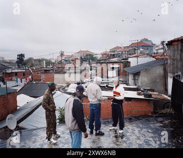 Les jeunes habitants du bidonville de Barrio 6 de Maio à Lisbonne sont vus se rassembler sur les toits de leur quartier en 2006. La photo capture un moment franc de la vie communautaire et de la vie urbaine. Banque D'Images