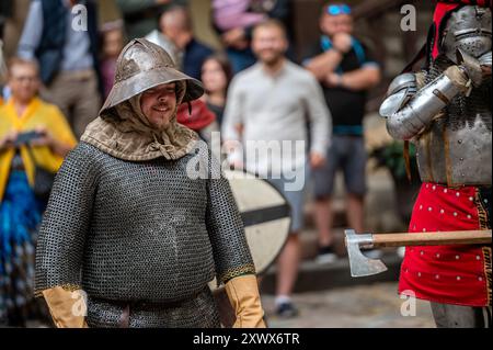 Jaunpils, Lettonie - 10 août 2024 : les participants en tenue médiévale s'engagent avec la foule lors d'un événement historique. Banque D'Images