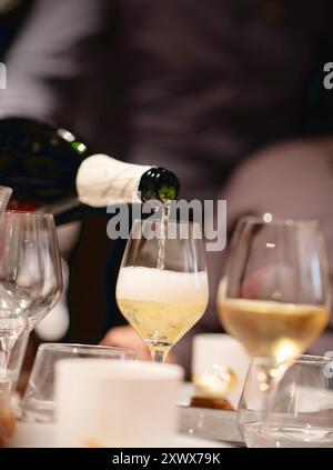 Sommelier dans un restaurant servant du vin blanc mousseux Banque D'Images