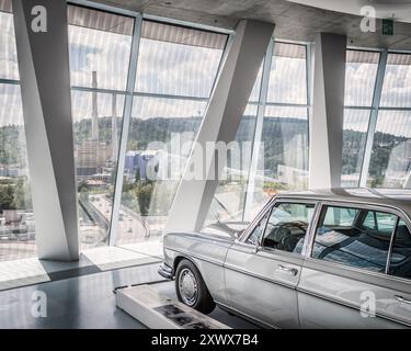 Découvrez l'élégance classique d'une voiture Mercedes d'époque exposée au musée Mercedes Benz de Stuttgart, en Allemagne. Le musée dispose de fenêtres panoramiques offrant des vues panoramiques, mêlant patrimoine automobile et architecture moderne. Banque D'Images