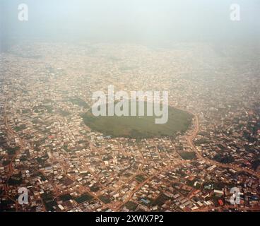 Photographie aérienne capturant le vaste paysage urbain de Lagos, au Nigeria avec un espace vert proéminent au centre. Prise en 2009, cette image met en valeur la densité urbaine et les espaces naturels de la ville. Banque D'Images