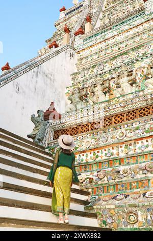 Visiteuse allant jusqu'à la flèche centrale ou Phraprang de Wat Arun (le temple de l'aube), l'un des monuments emblématiques de Bangkok, en Thaïlande Banque D'Images