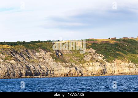 Les falaises de la côte du Yorkshire montrent clairement les couches de roches sédimentaires de l'ère jurassique. Les roches molles sont constamment érodées. Banque D'Images