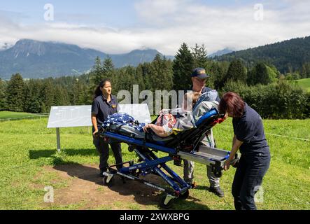 Oberstdorf, Allemagne. 20 août 2024. Rima Schucht (gauche-droite), Norbert Rzadki et Anita Sräga de l'Arbeiter-Sarmariter-Bund (ASB) sont à l'Alpe Dornach avec Kerstin Lindemann (M), couché sur une civière. Sous la devise « oser faire les derniers souhaits », ASB transporte les patients sous traitement vers des lieux spéciaux pour réaliser leurs derniers souhaits et rendre possibles des expériences spéciales. Crédit : Stefan Puchner/dpa/Alamy Live News Banque D'Images