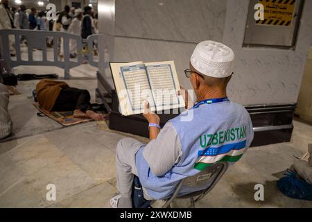 La Mecque, Arabie Saoudite - 6 juin 2024 : un vieil homme, pèlerin du Hadj et de la Oumrah d'Ouzbékistan assis et lisant le Coran à Masjidil Haram, Grande Mosquée de ma Banque D'Images