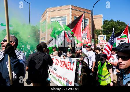 Chicago, États-Unis. 19 août 2024. Un manifestant tient une fusée de fumée verte pendant la « marche sur le DNC » le premier jour de la Convention nationale démocrate. Des militants sont rassemblés à Chicago pour organiser des manifestations pendant la convention, qui se déroule du 19 au 22 août. Crédit : SOPA images Limited/Alamy Live News Banque D'Images