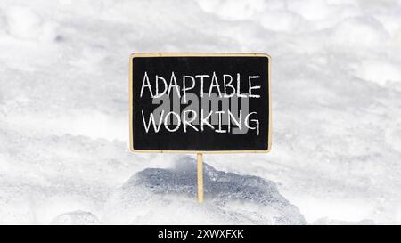 Symbole de travail adaptable. Mots conceptuels adaptables travaillant sur un beau tableau noir jaune. Beau fond de neige blanc. Travail adaptable aux entreprises Banque D'Images