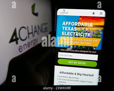 Personne tenant le téléphone portable avec la page Web de la compagnie d'électricité de détail américaine 4Change Energy devant le logo. Concentrez-vous sur le centre de l'écran du téléphone. Banque D'Images