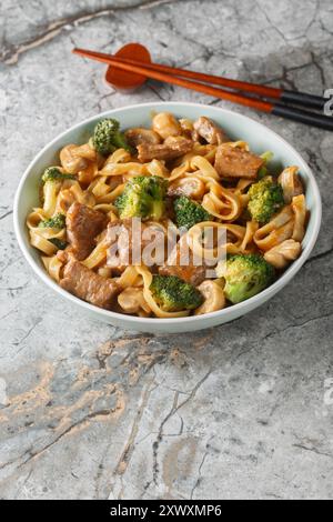 Nouilles de bœuf maison avec champignons et brocoli en gros plan sur le bol sur la table. Vertical Banque D'Images