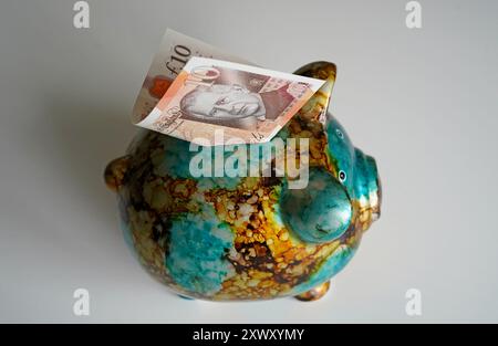 Billet de 10 £ émis par la Banque d'Angleterre représentant un portrait du roi Charles III dans une tirelire. Date de la photo : mardi 20 août 2024. Banque D'Images