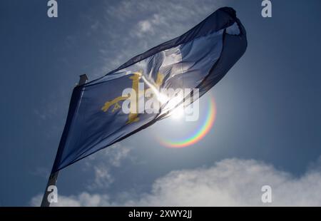 Principauté des Asturies drapeau flottant dans une brise vive contre la lumière Banque D'Images