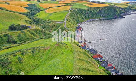 Crovie Aberdeenshire Écosse champs d'orge doré en été au-dessus des toits rouges des maisons Banque D'Images