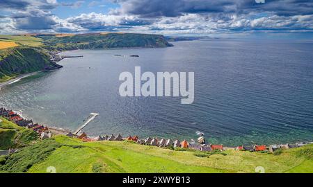 Crovie Aberdeenshire Écosse le Moray Firth et les nuages de pluie en été au-dessus des toits rouges des maisons Banque D'Images