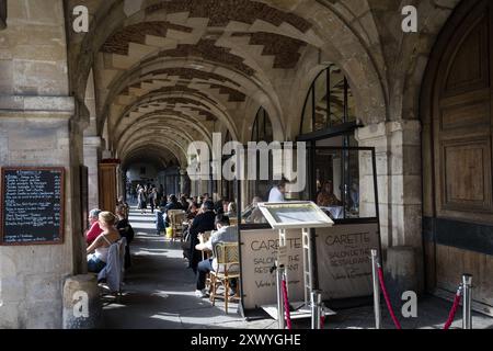 Place des Voges, Paris, France - 21 mars 2024 : restaurant français classique sous le soleil printanier. Banque D'Images