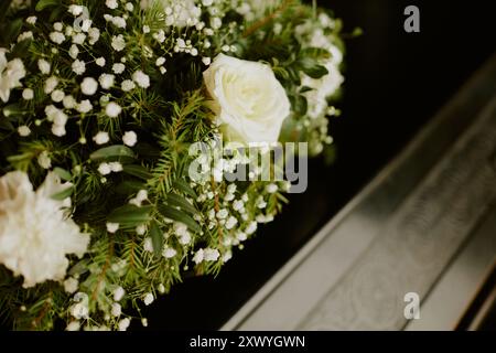 Gros plan moyen de roses blanches avec arbre à fourrure sur cercueil en bois Banque D'Images