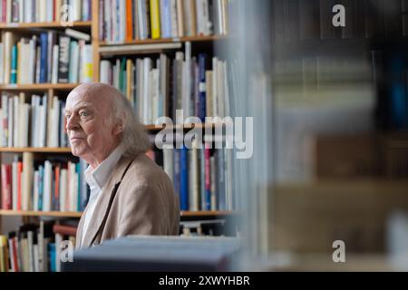 Cologne, Allemagne. 21 août 2024. Le libraire d'antiquaires Klaus Willbrand figure parmi les livres de sa librairie d'occasion à Sülz. À 83 ans, Willbrand est devenue une star TikTok et Instagram. Crédit : Rolf Vennenbernd/dpa/Alamy Live News Banque D'Images