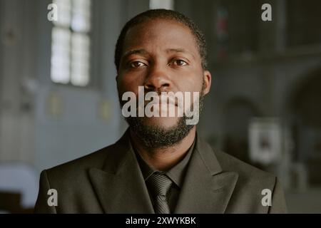 Portrait d'homme afro-américain vêtu d'un costume noir, il regardant la caméra avec tristesse dans les yeux Banque D'Images