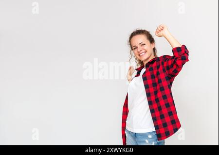 Femme portant des vêtements décontractés étirant et souriant sur fond gris clair. Banque D'Images