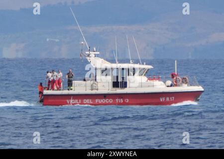 Le bateau de plongée des pompiers avec le sac de corps retournant au port de Porticello. Deux corps ont été trouvés lors de la recherche de six personnes portées disparues suite au naufrage du yacht de luxe Bayesian au large des côtes siciliennes. Date de la photo : mercredi 21 août 2024. Banque D'Images