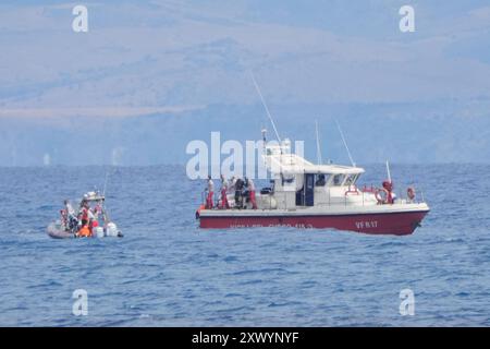 Le bateau de plongée des pompiers avec le sac de corps retournant au port de Porticello. Deux corps ont été trouvés lors de la recherche de six personnes portées disparues suite au naufrage du yacht de luxe Bayesian au large des côtes siciliennes. Date de la photo : mercredi 21 août 2024. Banque D'Images