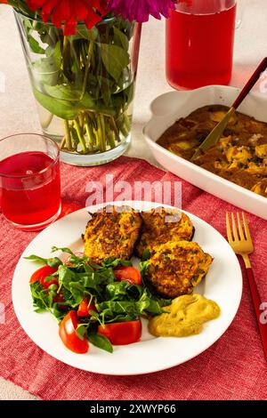 Savourez un petit déjeuner équilibré et appétissant composé de crêpes aux courgettes avec laitue fraîche et tomates, accompagné d'une compote de cerises et d'une délicieuse tarte aux pêches pour un repas matinal satisfaisant Banque D'Images