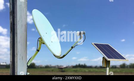 Une image d'une vieille antenne parabolique montée sur un poteau, jumelée à un panneau solaire pour obtenir de l'énergie, permettant la communication et la réception de nouvelles dans la télécommande A. Banque D'Images