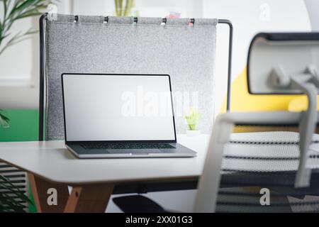 Ouvrez l'ordinateur portable. Maquette d'écran blanc vide. Intérieur d'espace de bureau Banque D'Images