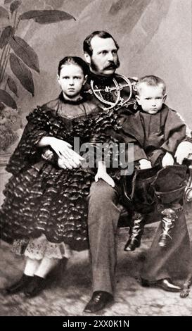 Empereur Alexandre II avec les enfants : Sergei et Maria. 1860-1861 cette photographie, prise en 1860 ou 1861, montre le tsar Alexandre II (1818-81, gouverné en 1855-81), avec deux de ses huit enfants : la grande-duchesse Maria Alexandrovna (née en 1853) et le grand-duc Sergueï Alexandrovitch (né en 1857). Alexandre est assis sur une chaise, aux trois quarts à sa gauche, portant un uniforme militaire. La grand-duchesse est appuyée sur le genou droit de son père, tournée vers l'avant ; le grand-duc est assis sur la jambe gauche de son père. Alexandre était très respecté pour son émancipation des serfs en 1861, et ses réformes intérieures incluaient Banque D'Images