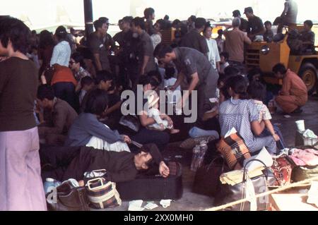 L'évacuation aérienne des Vietnamiens assiégés de Saigon vers les États-Unis a été effectuée après l'opération Babylift. Des militants et des civils vietnamiens attendent leur voyage C-141 pendant l'escale. Utapo RTNAF, Thaïlande. 29 avril 1975 Banque D'Images