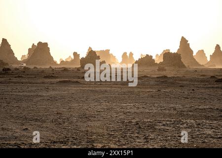 Paysage lunaire de cheminées calcaires formations rocheuses géologiques dans un coucher de soleil rayons au fond du lac salé séché Abbe, Djibouti Banque D'Images