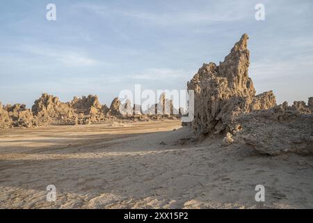 Paysage lunaire de cheminées calcaires formations rocheuses géologiques dans un coucher de soleil rayons au fond du lac salé séché Abbe, Djibouti Banque D'Images