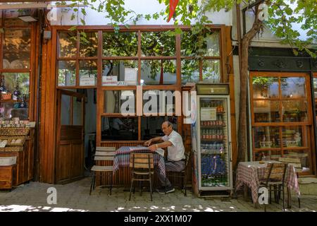 Safranbolu, Turquie - 5 août 2024 : un homme lit le journal en buvant du thé dans la vieille ville de Safranbolu en Turquie. Banque D'Images