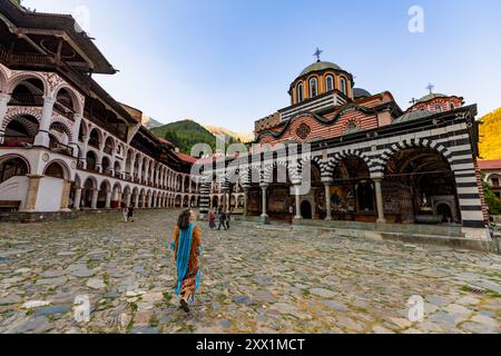 Femme marchant vers le monastère de Rila, site du patrimoine mondial de l'UNESCO, Bulgarie, Europe Banque D'Images