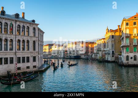 Maisons colorées et Camerlenghi Palace vu de l'autre côté du Grand canal avec gondoles traditionnelles au coucher du soleil, Venise, Vénétie, Italie Banque D'Images