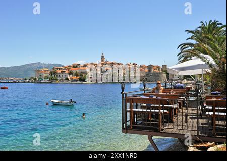 Terrasse de café sur pilotis, baie de Korcula vieille ville, île de Korcula, Croatie, Europe du Sud-est Banque D'Images