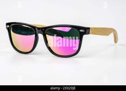 Lunettes de soleil miroir rose avec des cadres en bambou isolés sur un fond blanc. Banque D'Images