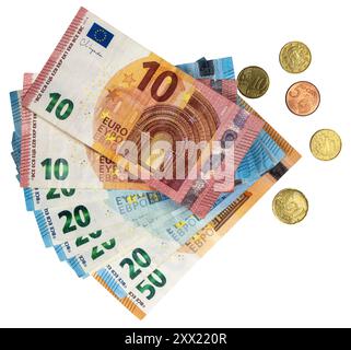 Vue de dessus d'une pile de billets en euros et de quelques pièces dispersées à proximité. Banque D'Images