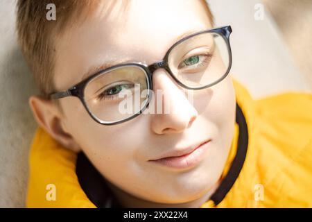 Vue aérienne rapprochée d'un garçon souriant portant des lunettes Banque D'Images