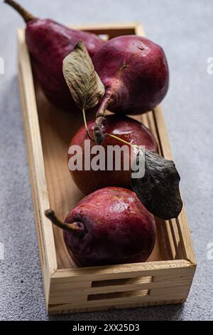 Vue aérienne de quatre poires Bartlett rouges dans une boîte en bois Banque D'Images