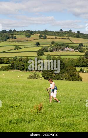 Femme marchant sur le sentier de longue distance Offa's Dyke dans la campagne galloise du Monmouthshire pays de Galles Banque D'Images