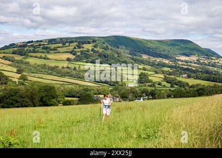 Femme marchant le sentier de longue distance Offa's Dyke dans la campagne galloise du Monmouthshire près de Pandy, Monmouthshire, pays de Galles Banque D'Images