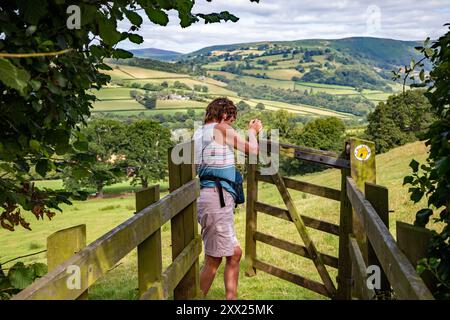 Femme ouvrant la porte marchant le sentier Offa's Dyke longue distance dans la campagne galloise du Monmouthshire près de Llangattock Lingoed, Monmouthshire, pays de Galles Banque D'Images